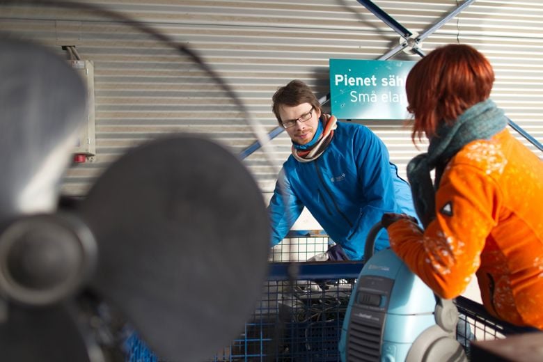 A man and a woman at a collection point for small electric and electronic equipment.