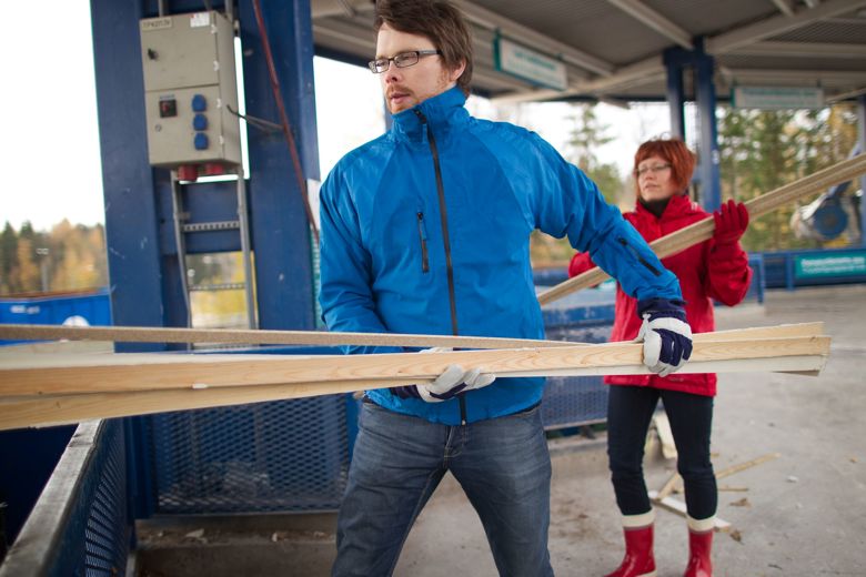 A man and a woman carry old boards and mouldings.
