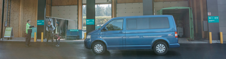 A van has stopped at a Sortti Station. Waste sorting points can be seen in the background.