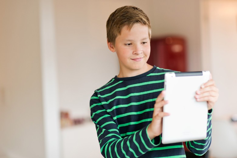 Lapsi käyttää taulutietokonetta.